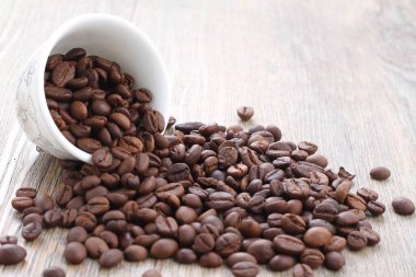Ahşap arka planda kavrulmuş kahve çekirdekleri.