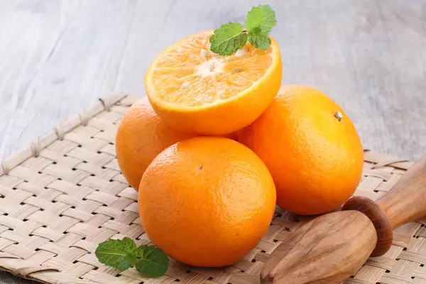 Mandalina ve yapraklar ahşap bir masada..