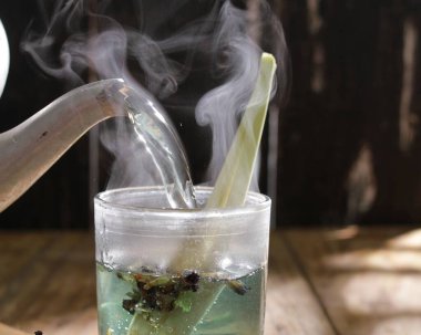 Eski ahşap masadaki cam bardakta yeşil çay