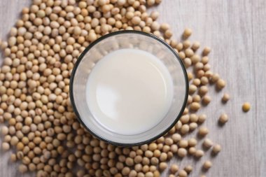 Beyaz arka planda beyaz bir kasede soya sütü, yakın plan -.