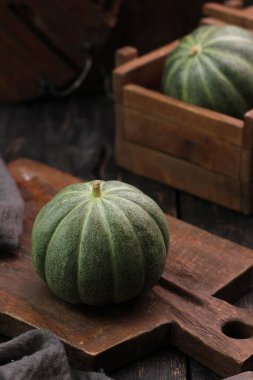 Tahta masada taze yeşil ve siyah kabak.