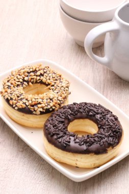 Donutlar ve kahve fincanı ahşap masada..