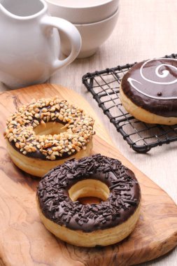 donuts with chocolate and icing on a wooden background