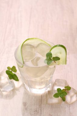 Açık gri masada naneli ve limonlu soğuk buz küpleri.