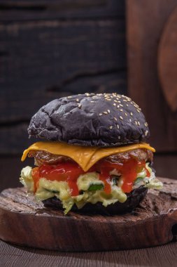 Siyah peynirli ve domates soslu lezzetli bir hamburger.