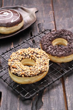 Çikolatalı donutlar ve ahşap masada fındıklar.