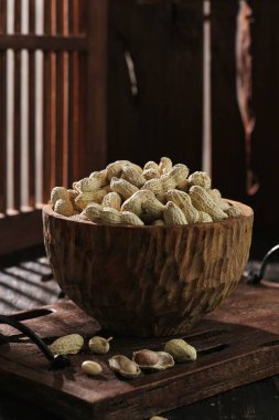 Köhne bir masada bir kase fıstık.