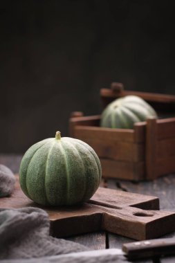 Tahta arka planda taze yeşil balkabağı