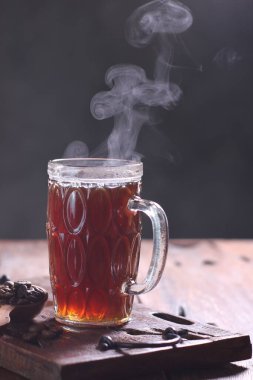 Bardakta sıcak kahve ve koyu arkaplanda sıcak çikolata.