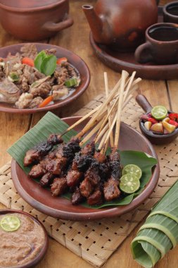 Fıstık soslu keçi satay ya da dilimlenmiş soğan, salatalık ve arnavut biberli soya sosuyla servis edilir.