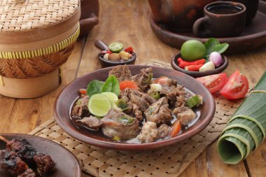 Fıstık soslu keçi satay ya da dilimlenmiş soğan, salatalık ve arnavut biberli soya sosuyla servis edilir.