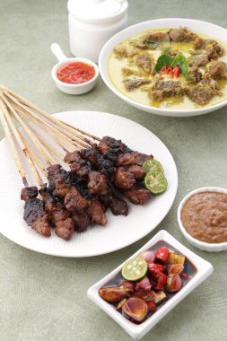 Endonezya yemeği, limon suyu, dilimlenmiş domates, dilimlenmiş bahar soğanı ve acı biber sosuyla servis edilen keçi çorbası.