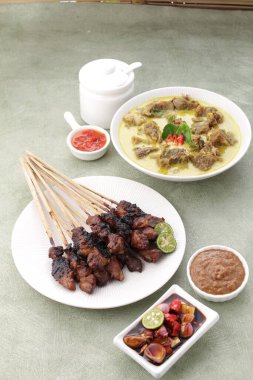 Endonezya yemeği, limon suyu, dilimlenmiş domates, dilimlenmiş bahar soğanı ve acı biber sosuyla servis edilen keçi çorbası.