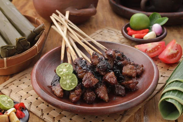 Fıstık soslu keçi satay ya da dilimlenmiş soğan, salatalık ve arnavut biberli soya sosuyla servis edilir.