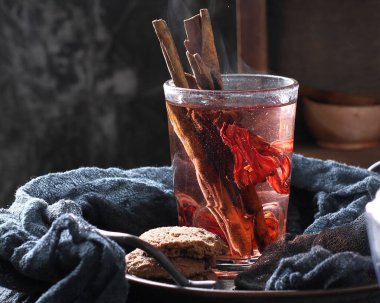 Bardakta sıcak çay ve kurutulmuş meyve.