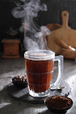 Kahve fincanı, sıcak içecek, tarçın çubukları ve arka planda anason yıldızı..