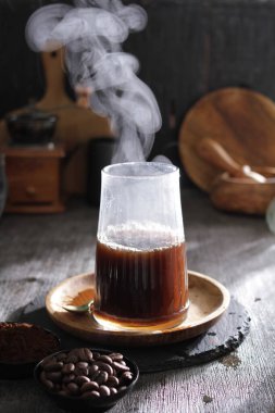 Tahta masada bir bardak sıcak kahve.