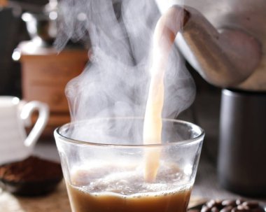 Masada buhar olan bir fincan kahve.