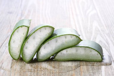 aloe vera beyaz ahşap arka planda dilimlenmiş.