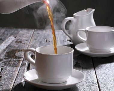 Bir fincan sıcak çay ve masada kaşık.