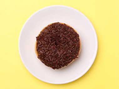 Çikolatalı kek, bir parça çikolatalı, sarı tabakta, beyaza izole edilmiş, üst manzara, yakın -