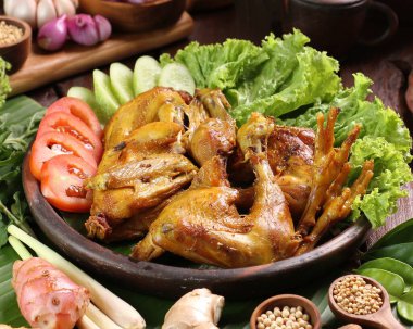 Ahşap masada ızgara tavuk ve sebze.