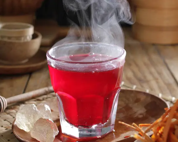 red hot drink with ice and lemon
