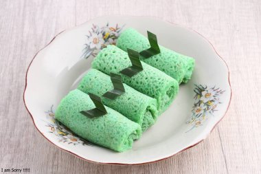 Tepesinde yaprak olan bir tabak yeşil yemek.