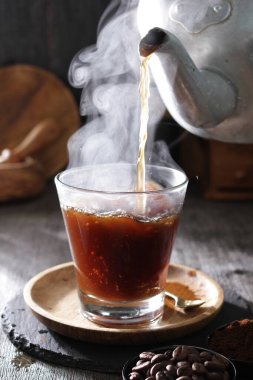 Bir çaydanlık fincana çay dolduruyor.