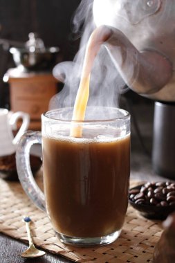 Bir fincan kahve, kaşık ve çaydanlık.