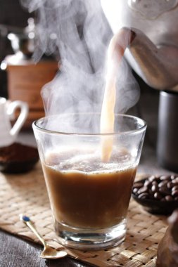 Bardağa doldurulan bir fincan kahve.