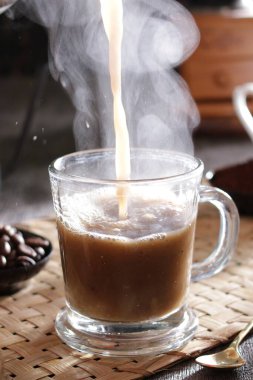 Bir fincan kahveyi kaşıkla dolduruyorlar.