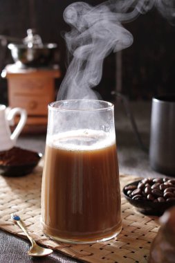 Masanın üzerinde dumanı tüten bir fincan kahve.