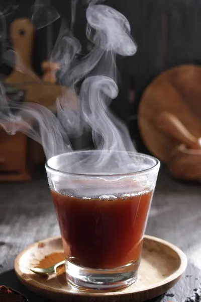a cup of hot tea with smoke rising out of it
