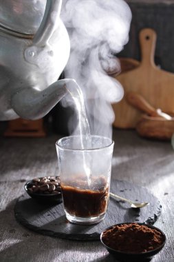 Bardağa doldurulan bir fincan kahve.