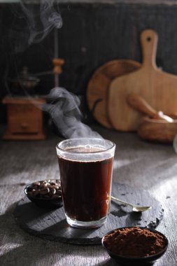 Bir fincan kahvenin kaşığı ve kaşığı masada dinleniyor.