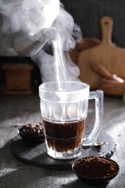 Masanın üzerinde dumanı tüten bir fincan kahve.