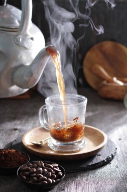 Bir çaydanlık fincana çay dolduruyor.