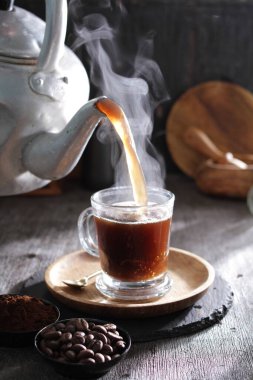 Bardağa doldurulmuş bir fincan kahve.