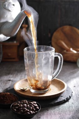 Bardağa doldurulmuş bir fincan kahve.