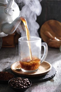 Bardağa doldurulmuş bir fincan kahve.