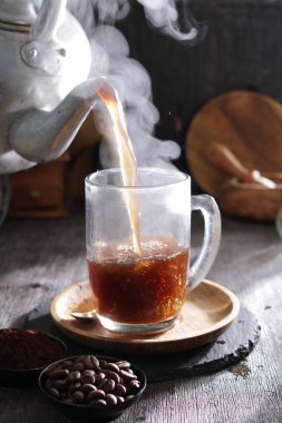 Bardağa doldurulmuş bir fincan kahve.