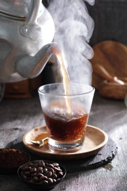 Bir çaydanlık fincana çay dolduruyor.