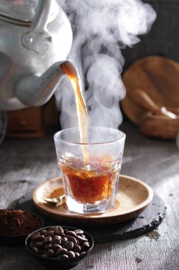 Bir çaydanlık fincana çay dolduruyor.