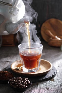 Bir çaydanlık fincana çay dolduruyor.