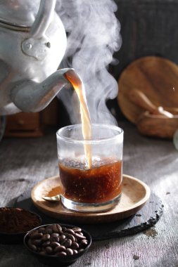 Bir çaydanlık fincana çay dolduruyor.