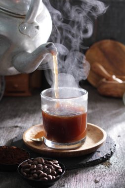 Bardağa doldurulmuş bir fincan kahve.