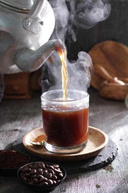 Bardağa doldurulmuş bir fincan kahve.