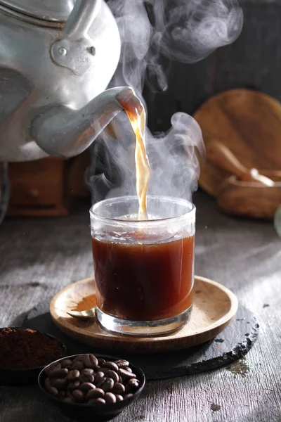 Bardağa doldurulmuş bir fincan kahve.