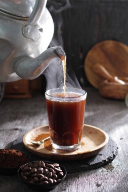 Bardağa doldurulmuş bir fincan kahve.